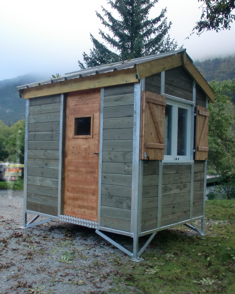 Présentation d'une cabane de téléski avec toit deux pentes, armature métallique et habillage bois.