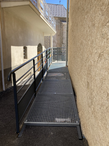 La rampe d'accès permet d'arriver au niveau de l'entrée du bâtiment.